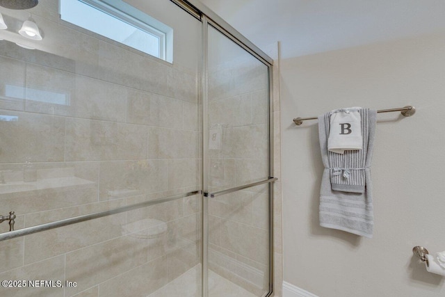 bathroom featuring a shower with shower door