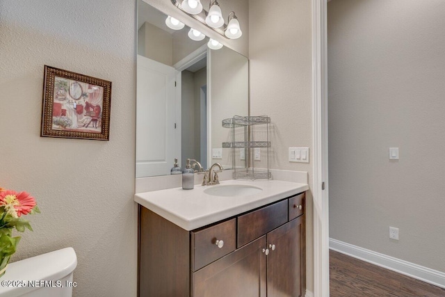 bathroom with vanity, hardwood / wood-style flooring, and toilet