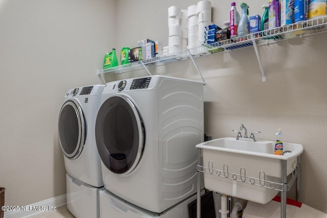 clothes washing area featuring washer and clothes dryer and sink