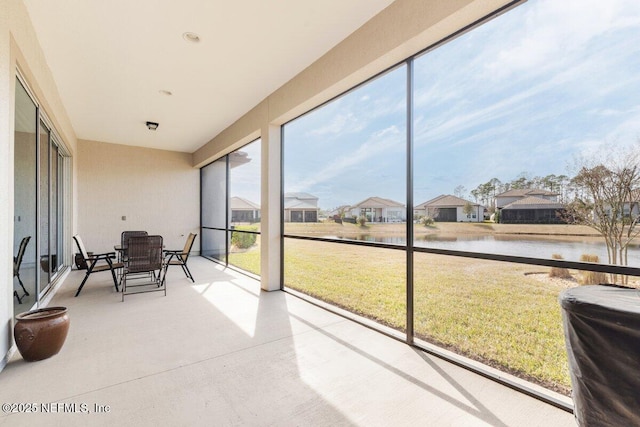 sunroom / solarium featuring a water view and a healthy amount of sunlight