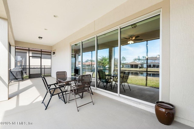 sunroom with a water view and ceiling fan