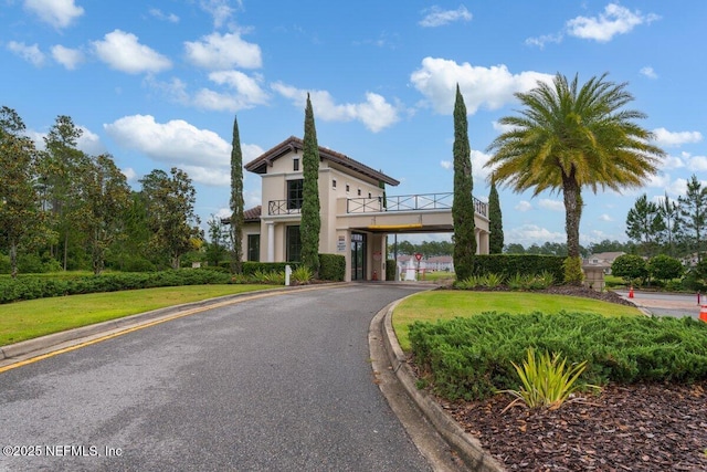 view of front of property featuring a balcony and a front lawn