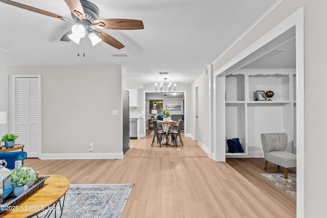 living room featuring light hardwood / wood-style floors and ceiling fan with notable chandelier