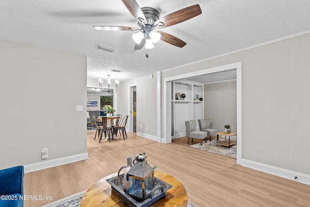 living room with wood-type flooring, ceiling fan with notable chandelier, and a textured ceiling