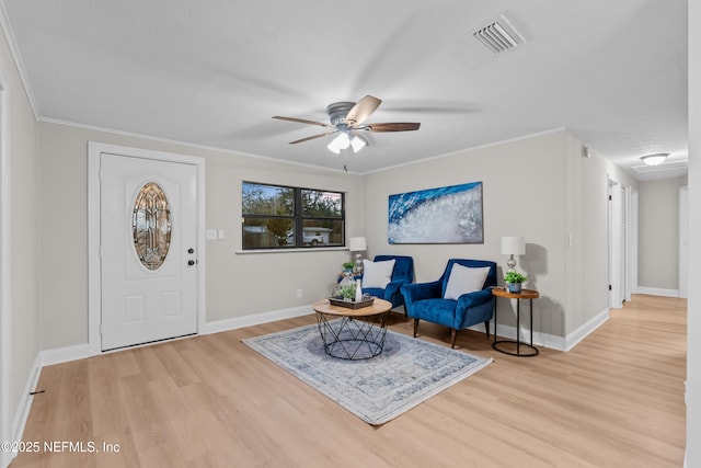 living area with plenty of natural light, light hardwood / wood-style flooring, ceiling fan, and ornamental molding