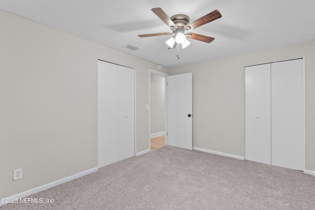 unfurnished bedroom featuring light colored carpet and ceiling fan