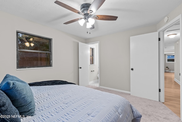 carpeted bedroom featuring ceiling fan and ensuite bathroom