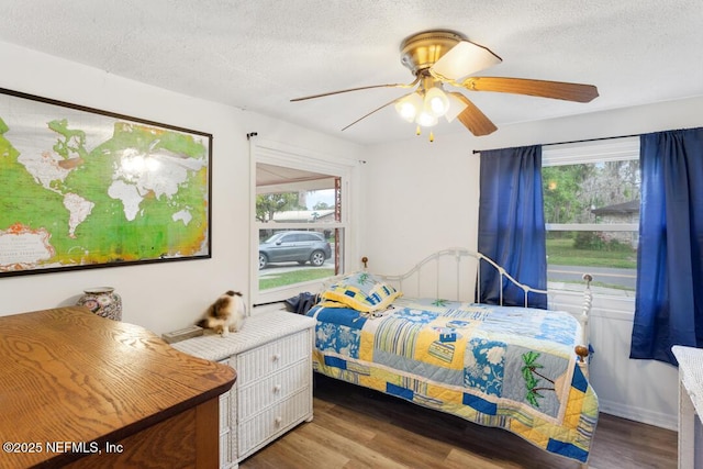 bedroom with ceiling fan, a textured ceiling, and hardwood / wood-style floors