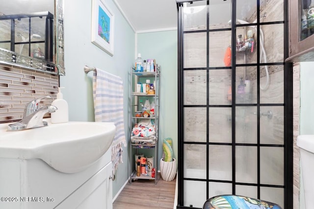 bathroom with crown molding, hardwood / wood-style flooring, and vanity