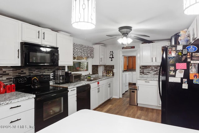 kitchen featuring black appliances, tasteful backsplash, white cabinets, and separate washer and dryer