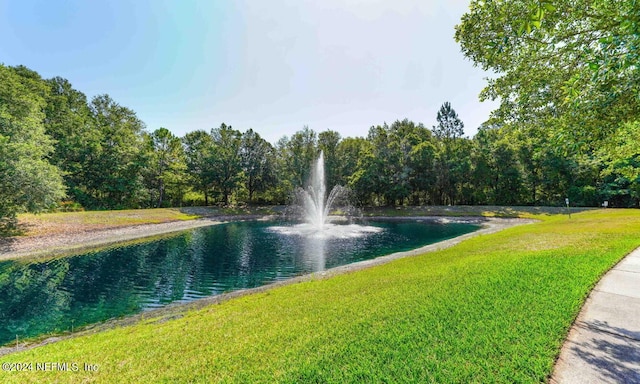 view of property's community featuring a yard and a water view