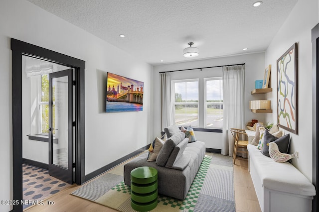 interior space featuring light wood-type flooring and a textured ceiling