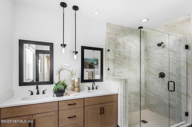 bathroom with a shower with shower door and vanity