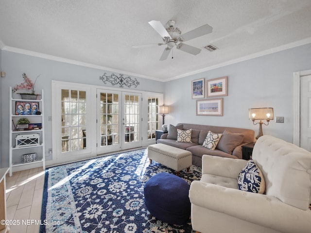 living room with crown molding, light hardwood / wood-style flooring, ceiling fan, french doors, and a textured ceiling