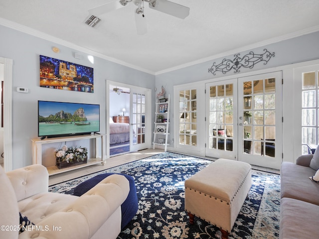 living room with ceiling fan, french doors, ornamental molding, and plenty of natural light