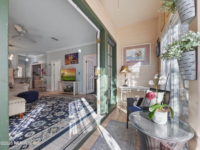 interior space with light tile patterned floors and ornamental molding