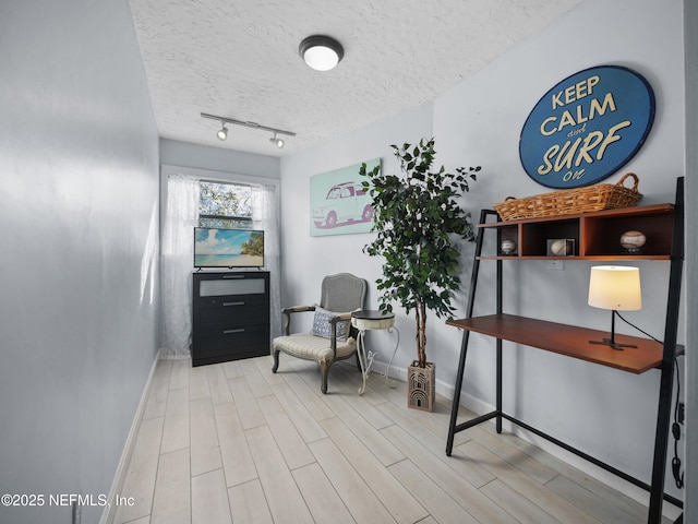 interior space featuring rail lighting and a textured ceiling