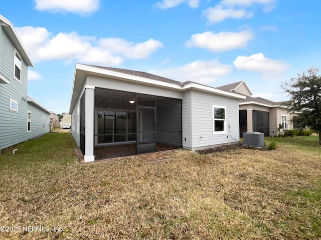 rear view of property featuring a yard and a sunroom