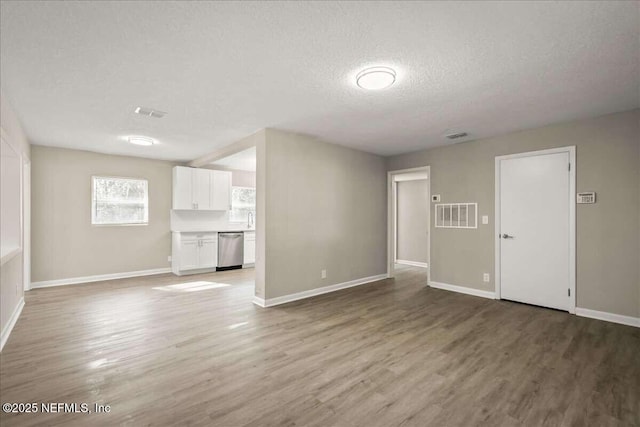 unfurnished living room featuring a textured ceiling and wood-type flooring