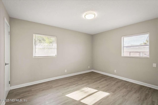 unfurnished room with a textured ceiling and hardwood / wood-style floors