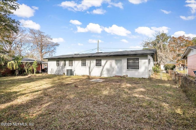 rear view of house featuring a lawn and central AC unit