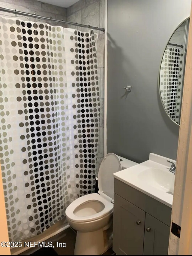 bathroom featuring vanity, a shower with shower curtain, and toilet