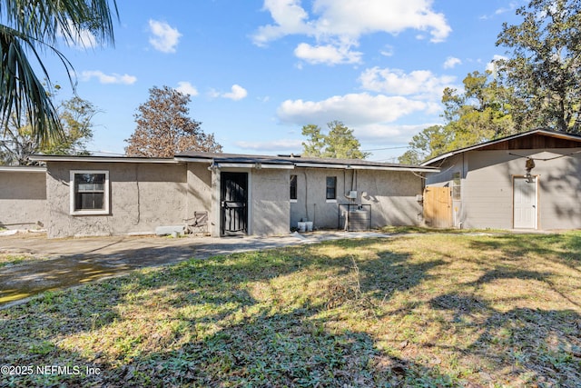 rear view of property featuring a yard and a patio