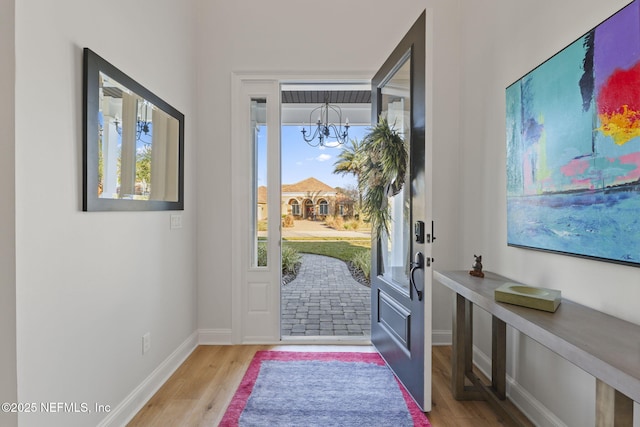 entrance foyer with a notable chandelier and light hardwood / wood-style flooring