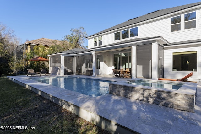 back of house with a patio area, a pool with hot tub, and a sunroom