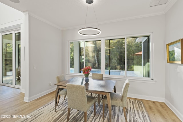 dining area featuring crown molding and light wood-type flooring