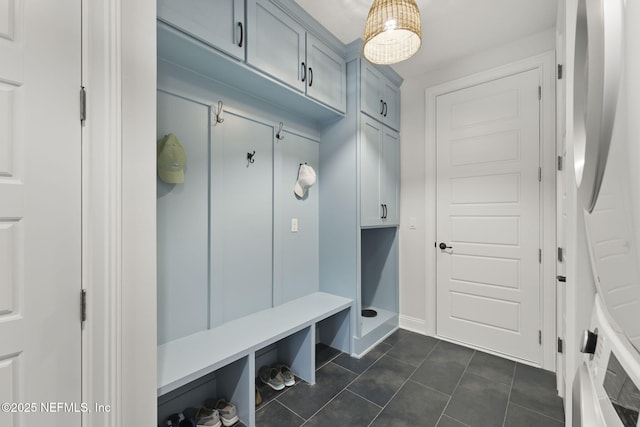 mudroom with dark tile patterned floors