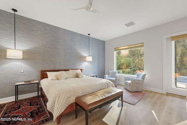 bedroom featuring multiple windows, access to outside, light hardwood / wood-style floors, and ceiling fan