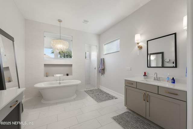 bathroom featuring vanity, an inviting chandelier, and plus walk in shower