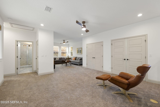 living area featuring ceiling fan and light carpet