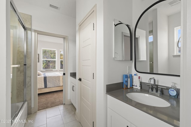 bathroom featuring tile patterned flooring, vanity, and tiled shower / bath combo