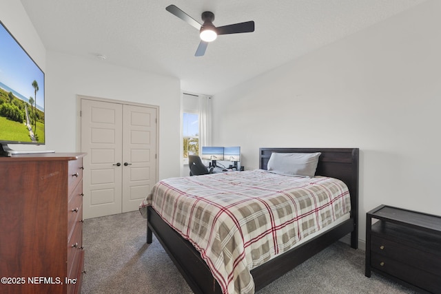 bedroom featuring dark carpet, a textured ceiling, a closet, and ceiling fan