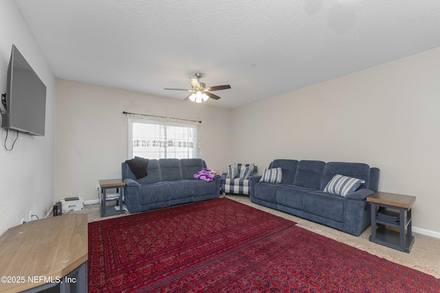 carpeted living room featuring ceiling fan and a textured ceiling