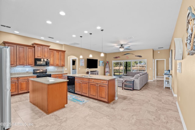 kitchen with a kitchen island, decorative light fixtures, sink, decorative backsplash, and black appliances