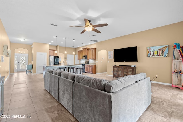 living room featuring sink, light tile patterned floors, and ceiling fan