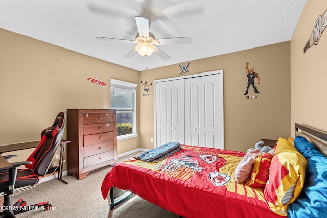 carpeted bedroom with ceiling fan, a closet, and a textured ceiling