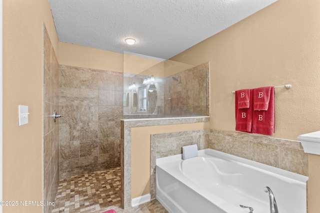 bathroom with plus walk in shower and a textured ceiling