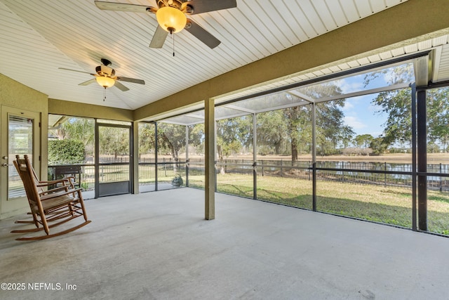 unfurnished sunroom featuring vaulted ceiling and a water view