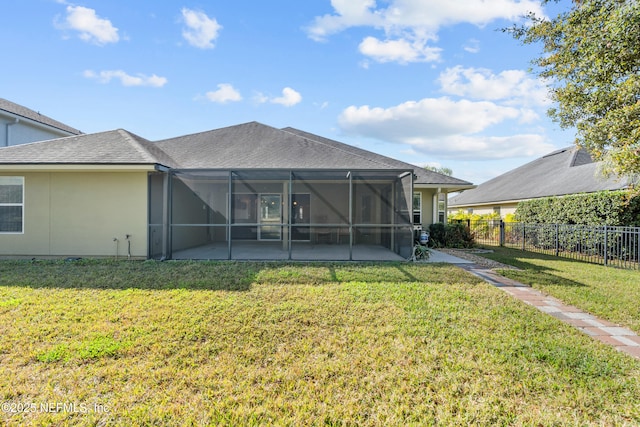 rear view of house with a yard, a patio area, and glass enclosure