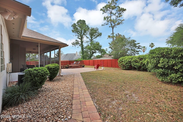 view of yard featuring central AC, a sunroom, and a patio