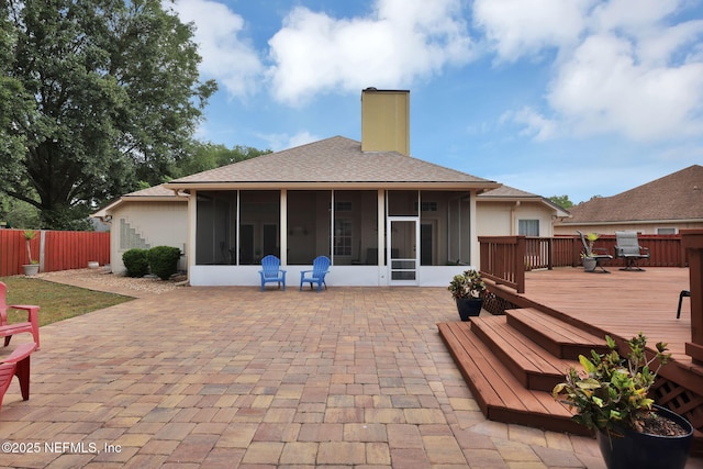 back of house with a wooden deck and a sunroom