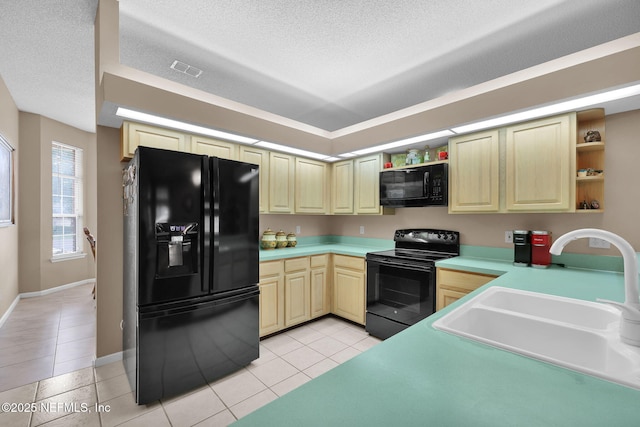 kitchen with light tile patterned floors, black appliances, sink, and a textured ceiling