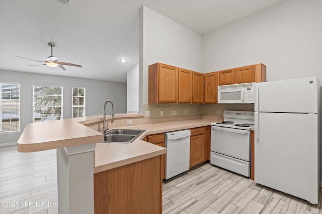 kitchen featuring sink, white appliances, a textured ceiling, kitchen peninsula, and ceiling fan