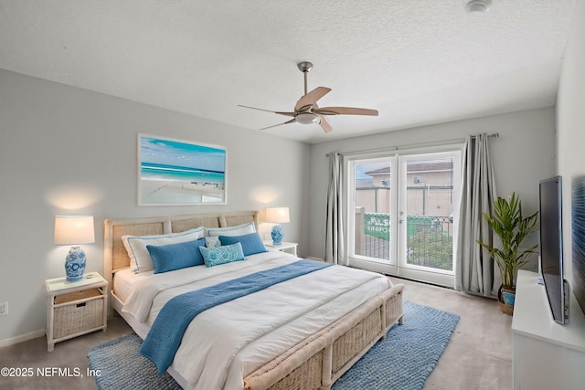 carpeted bedroom with access to exterior, a textured ceiling, and ceiling fan