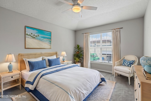 carpeted bedroom with ceiling fan and a textured ceiling