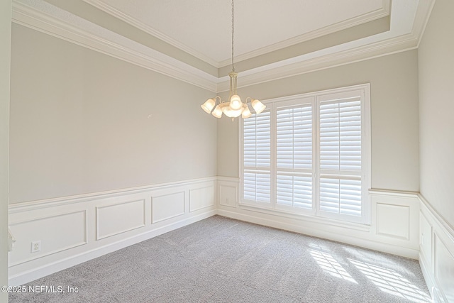 spare room featuring crown molding, a wealth of natural light, light colored carpet, and an inviting chandelier